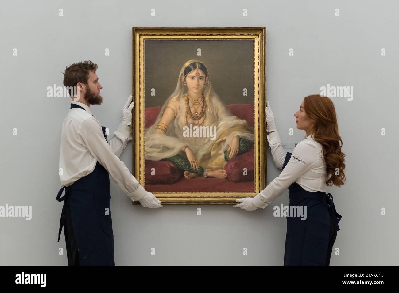 LONDON, UNITED KINGDOM - DECEMBER 01, 2023: Technicians hold a painting by Francesco Renaldi titled ‘Portrait of a Mughal lady, seated in an interior' (estimate: £300,000 - 500,000) during a photocall at Sotheby's auction house showcasing the highlights from the Old Masters Week Sales in London, United Kingdom on December 01, 2023. December's Masters Week Evening sale spans the early-fifteenth to the early-twentieth centuries and features a wide array of remarkable works from nearly every genre. (Photo by WIktor Szymanowicz/NurPhoto) Stock Photo