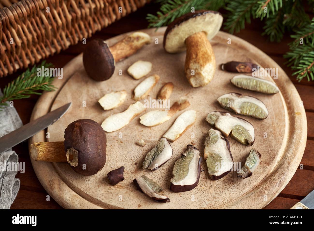 Whole and sliced fresh pine bolete mushrooms on a wooden table Stock Photo