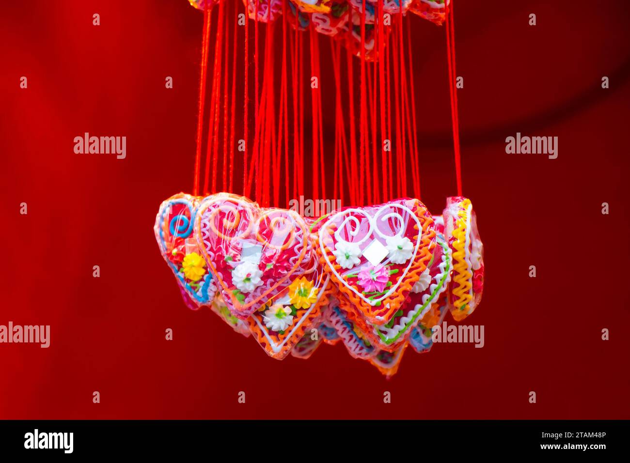 Red heart shaped lolly pops, sweetheart necklace on Christmas markets are traditional souvenir edible gifts, detail Stock Photo