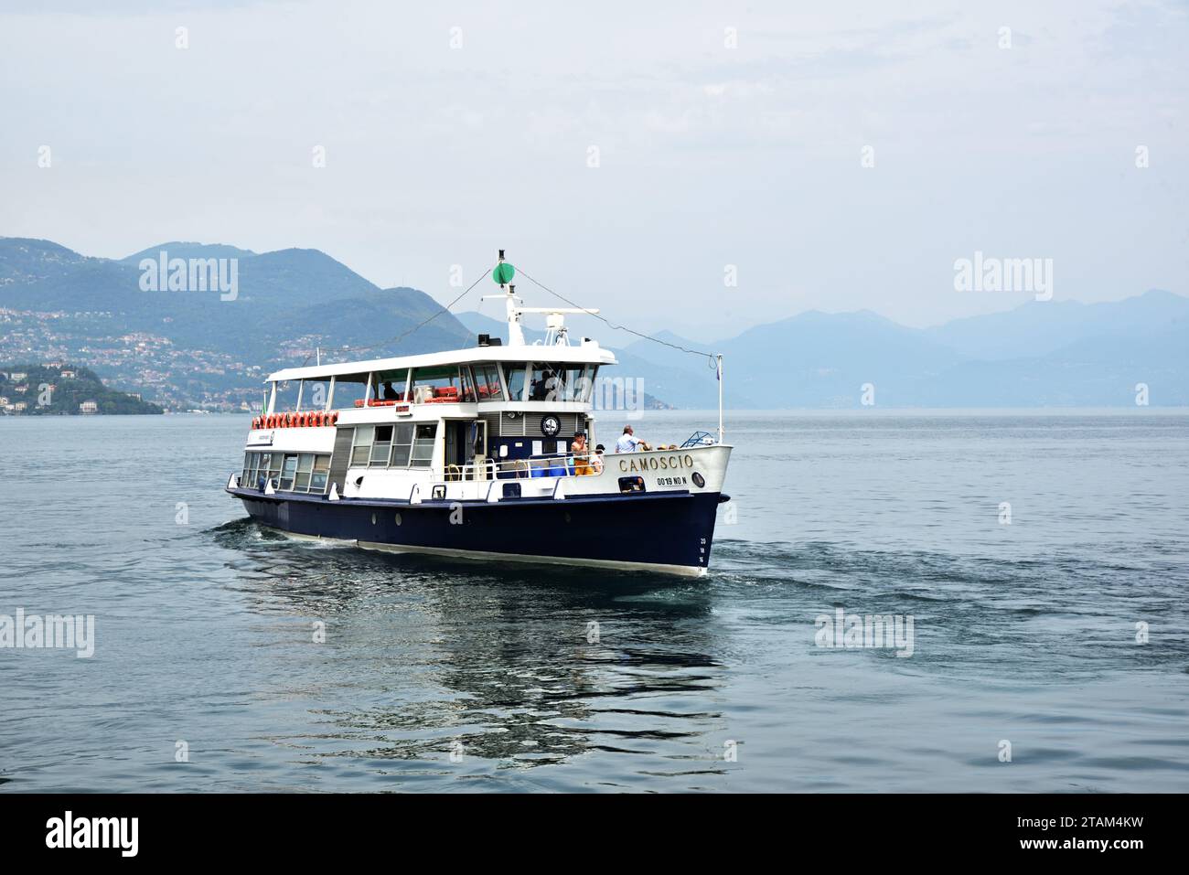 The passenger ferry Camoscio reverses from the pier at Stresa on Lake Maggiore. Built in 1972, it is one of six vessels in the Alpino class. Stock Photo