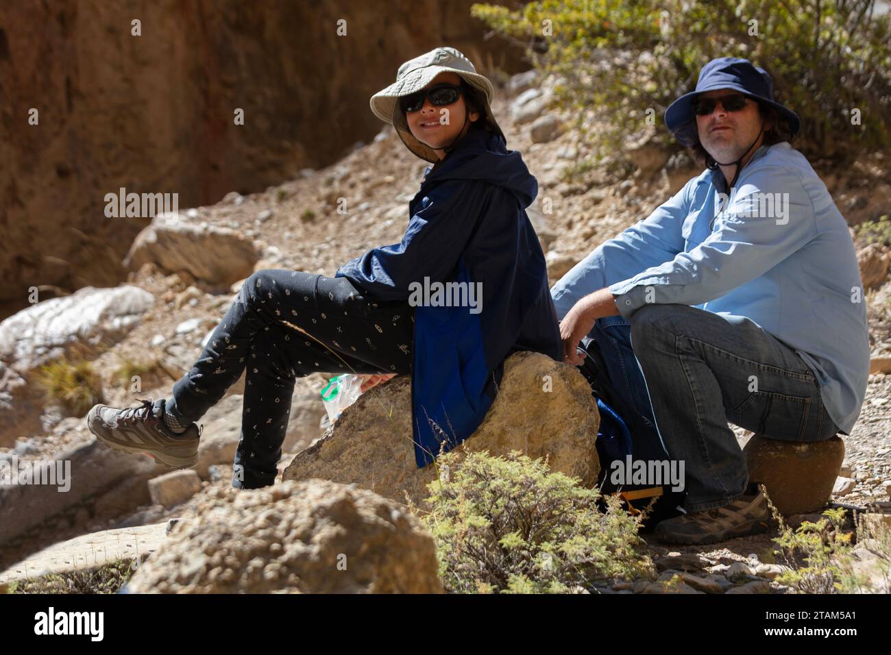 Bodhi Garrett and Vajra Garrett rest while trekking from  Samar to Syangboche on route to Chungsi Cave - Mustang District, Nepal Stock Photo