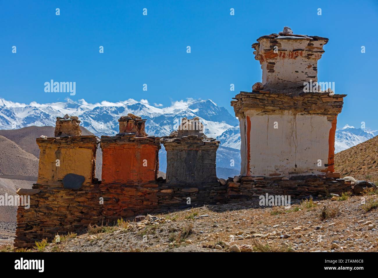 Chortens in the three colors representing the states of the human condition guard the entrance to Dhakmar village -  Mustang District, Nepal Stock Photo