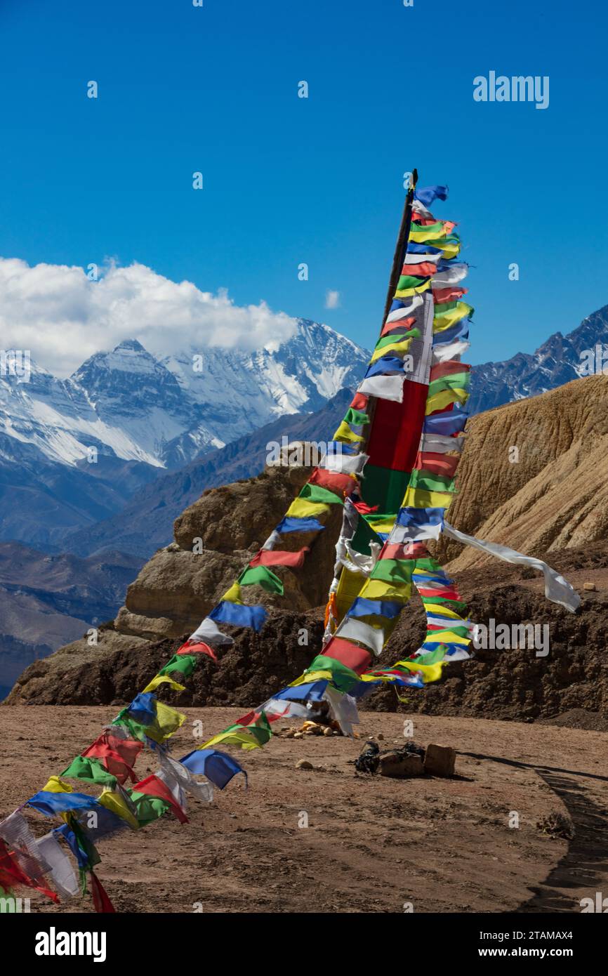 Prayer flags on the  pass from Yara to Tange village with views to the west of Jakriojagga Peak - Upper Mustang District, Nepal Stock Photo