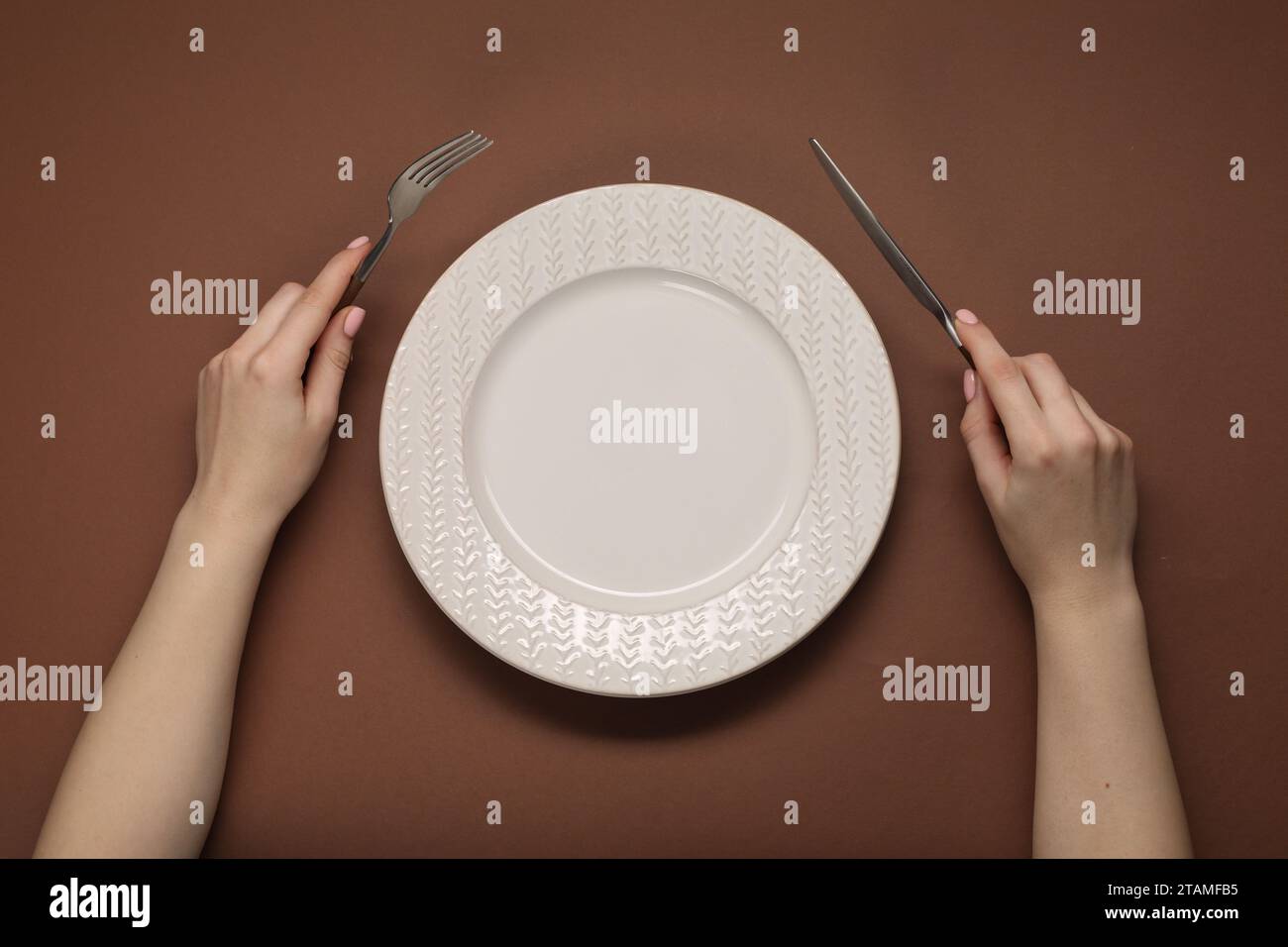 Brown hands holding fork knife hi-res stock photography and images - Alamy