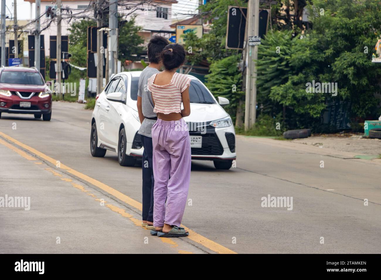 People stand in the middle of the road and wait to walk between moving