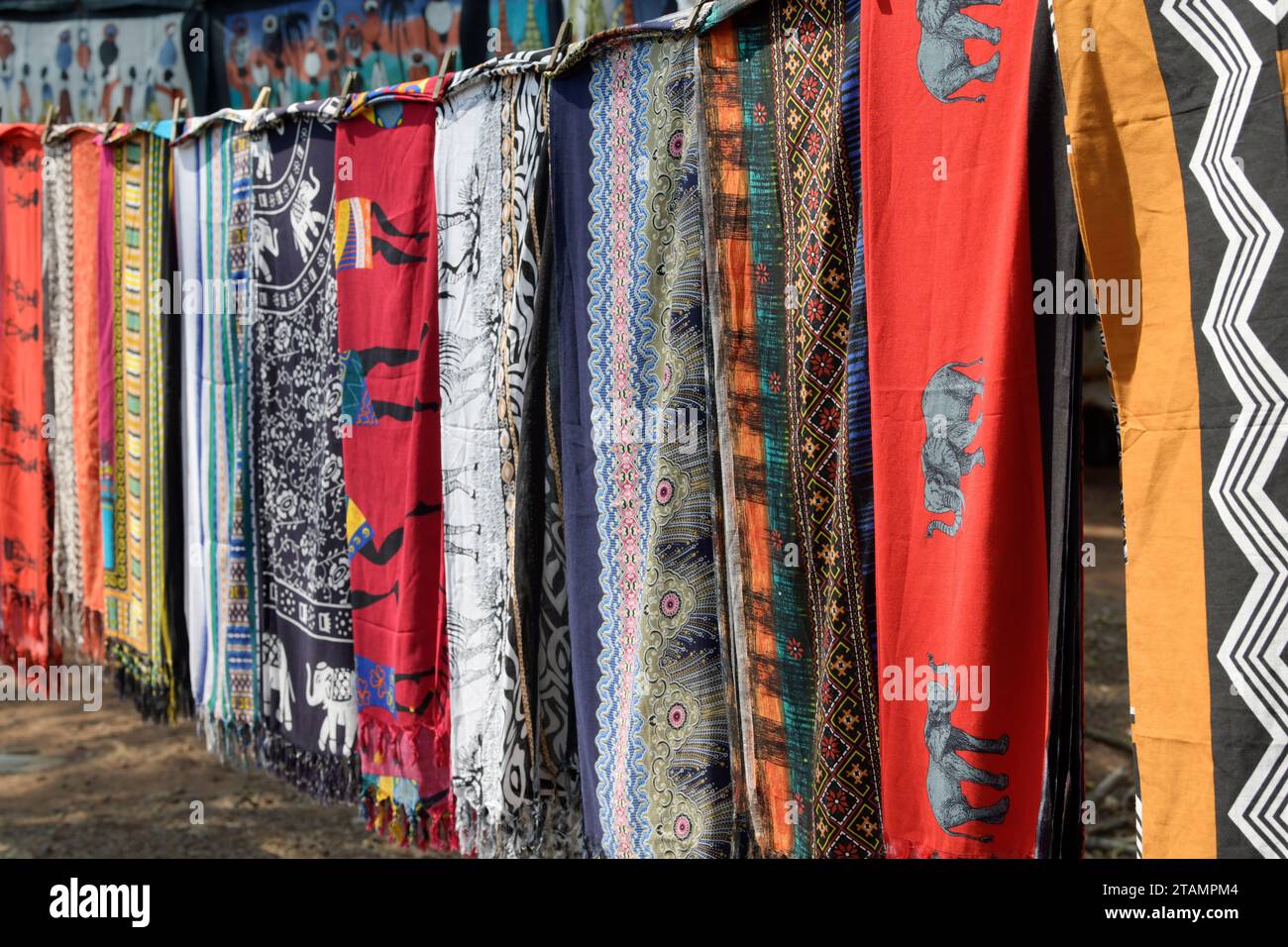 Beautiful printed table cloths hanging in row, curios for sale at Swazi Candles traditional African art market, Eswatini Swaziland, travel shopping Stock Photo