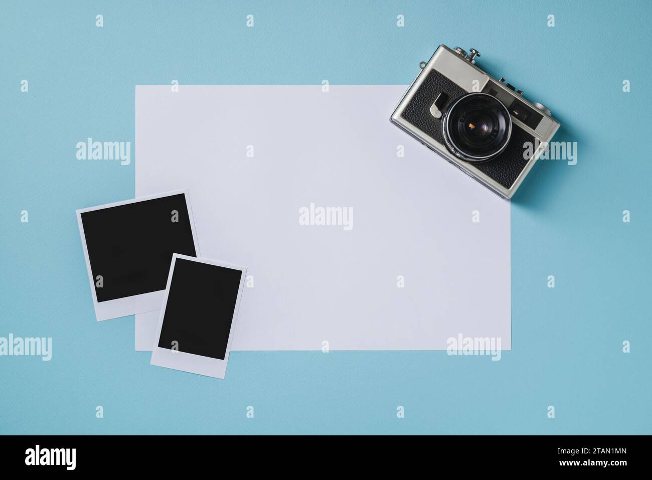 Vintage photo camera and empty photo frames on blue background. Travel moment concept Stock Photo