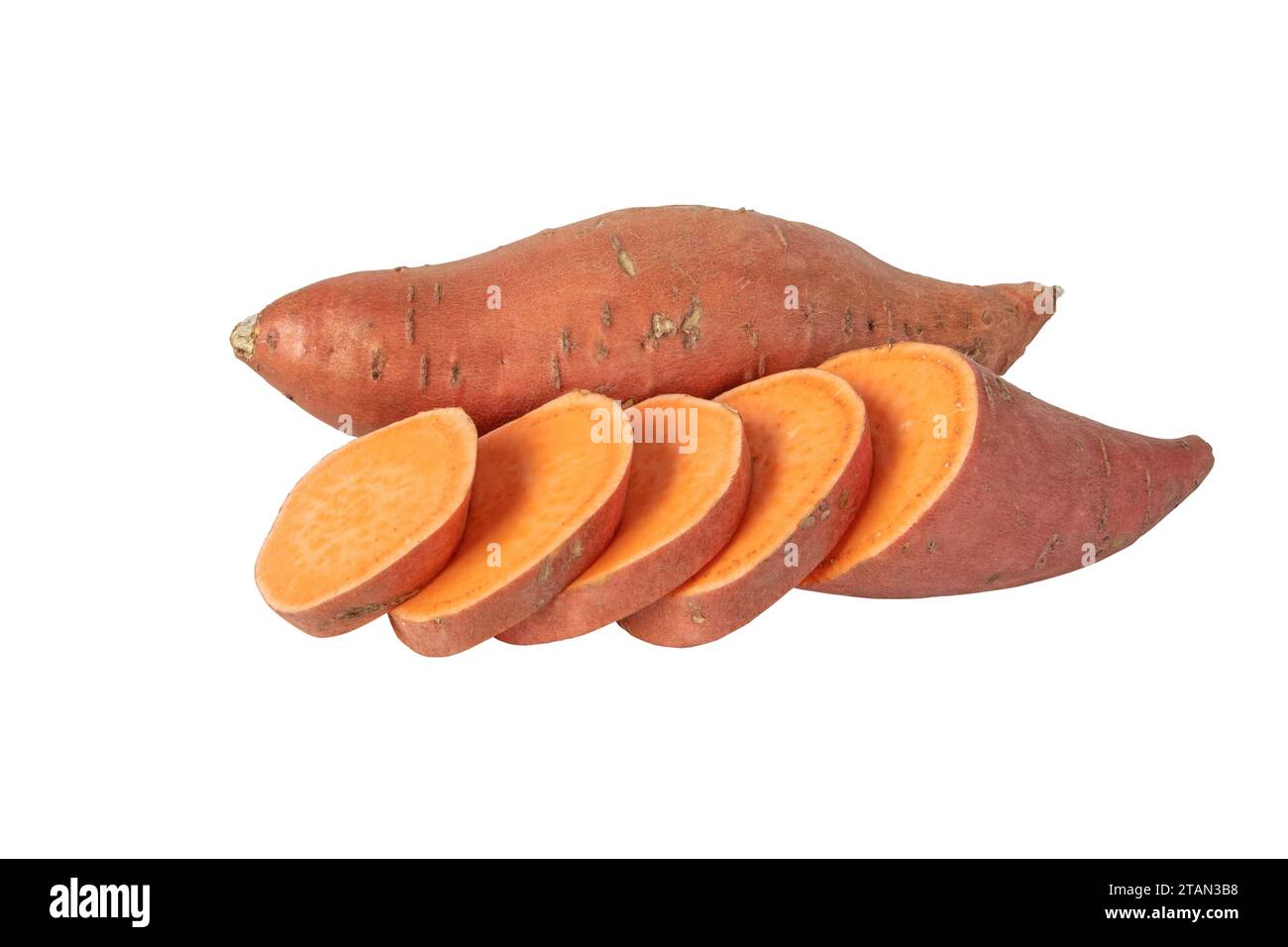 Sweet potato or boniato whole and sliced tubes with red skin and yellow flesh isolated on white. Vegetable food staple. Stock Photo