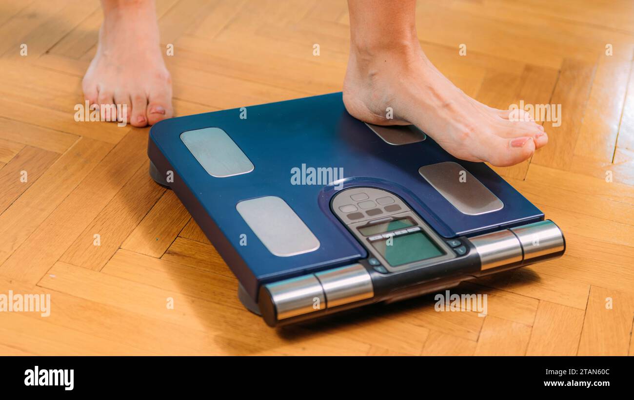 Woman using body composition scales Stock Photo Alamy