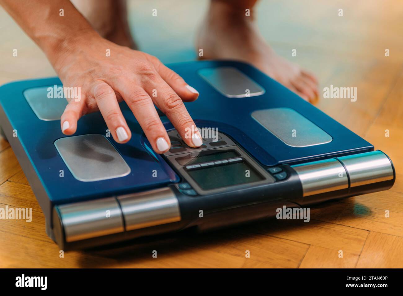 Woman using body composition scales Stock Photo Alamy