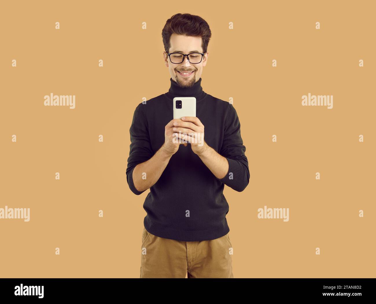 Portrait of young cheerful man using mobile phone Stock Photo