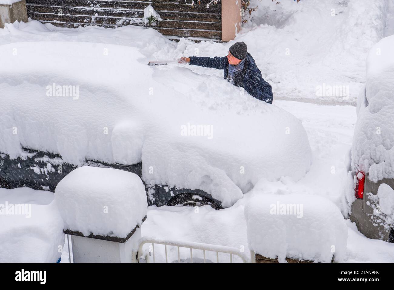 Münchner versucht sein Auto von einem halben Meter Schnee zu