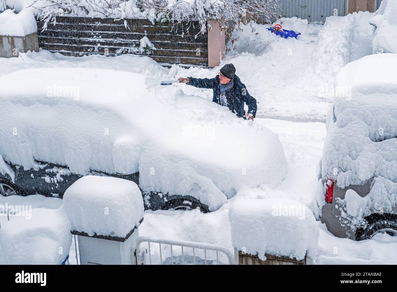 Münchner versucht sein Auto von einem halben Meter Schnee zu befreien,  Winterwonderland, München, 2. Dezember 2023 Deutschland, München, 2.  Dezember 2023, Münchner versucht mit einem Schneefeger sein Auto vom Schnee  zu befreien