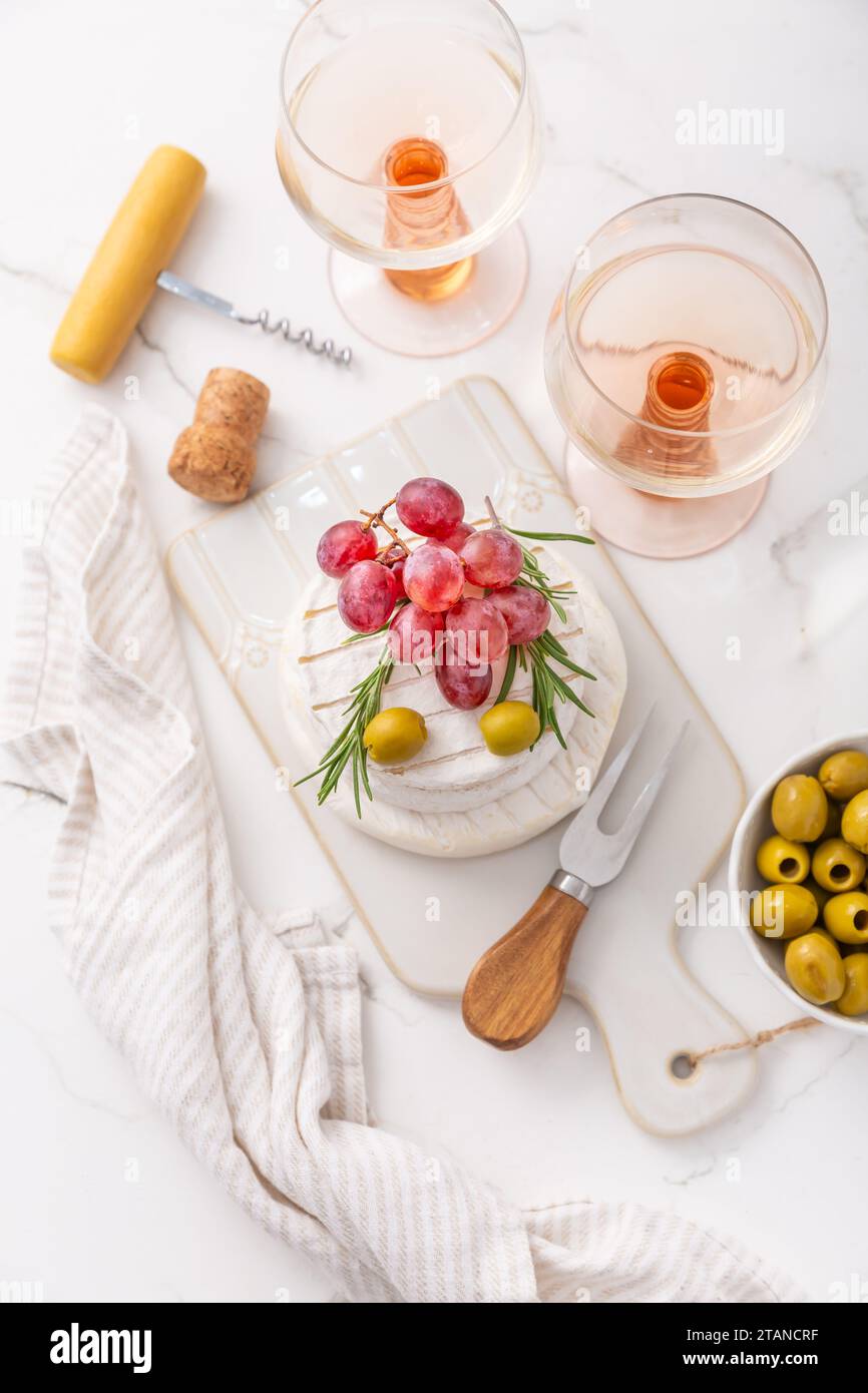 Cheese platter with French Camembert and Skyr cheese with grapes, olives and rose wine Stock Photo