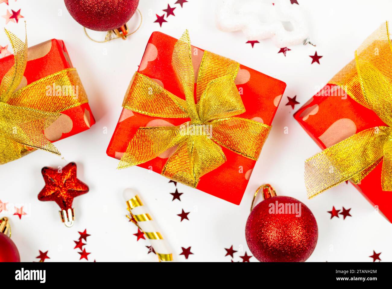 Red and gold christmas baubles, red gift boxes at white background ...