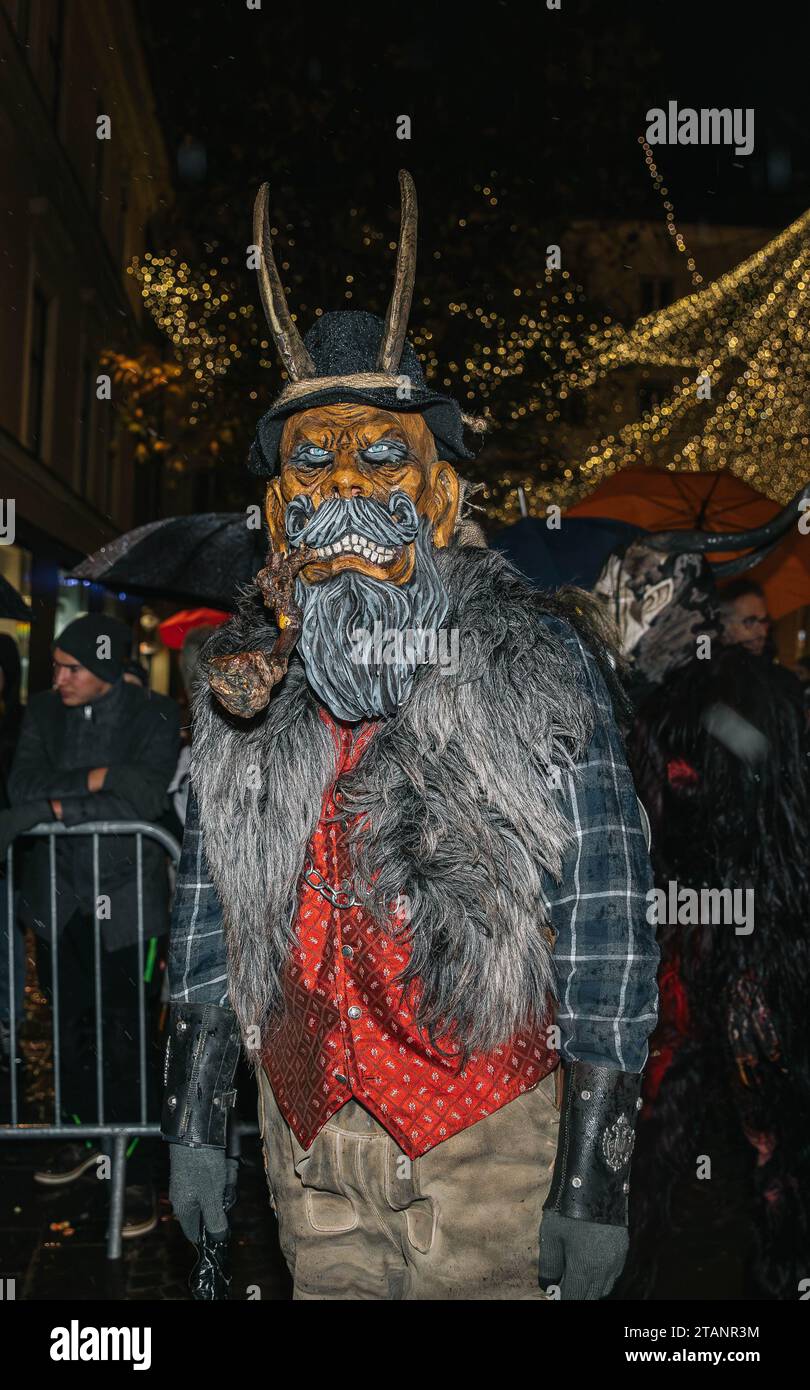 Villach, Austria - December 1, 2023: Krampuslauf parade, mask show of devils and St. Nicholas, fun show in the city center, more than 40 groups from C Stock Photo