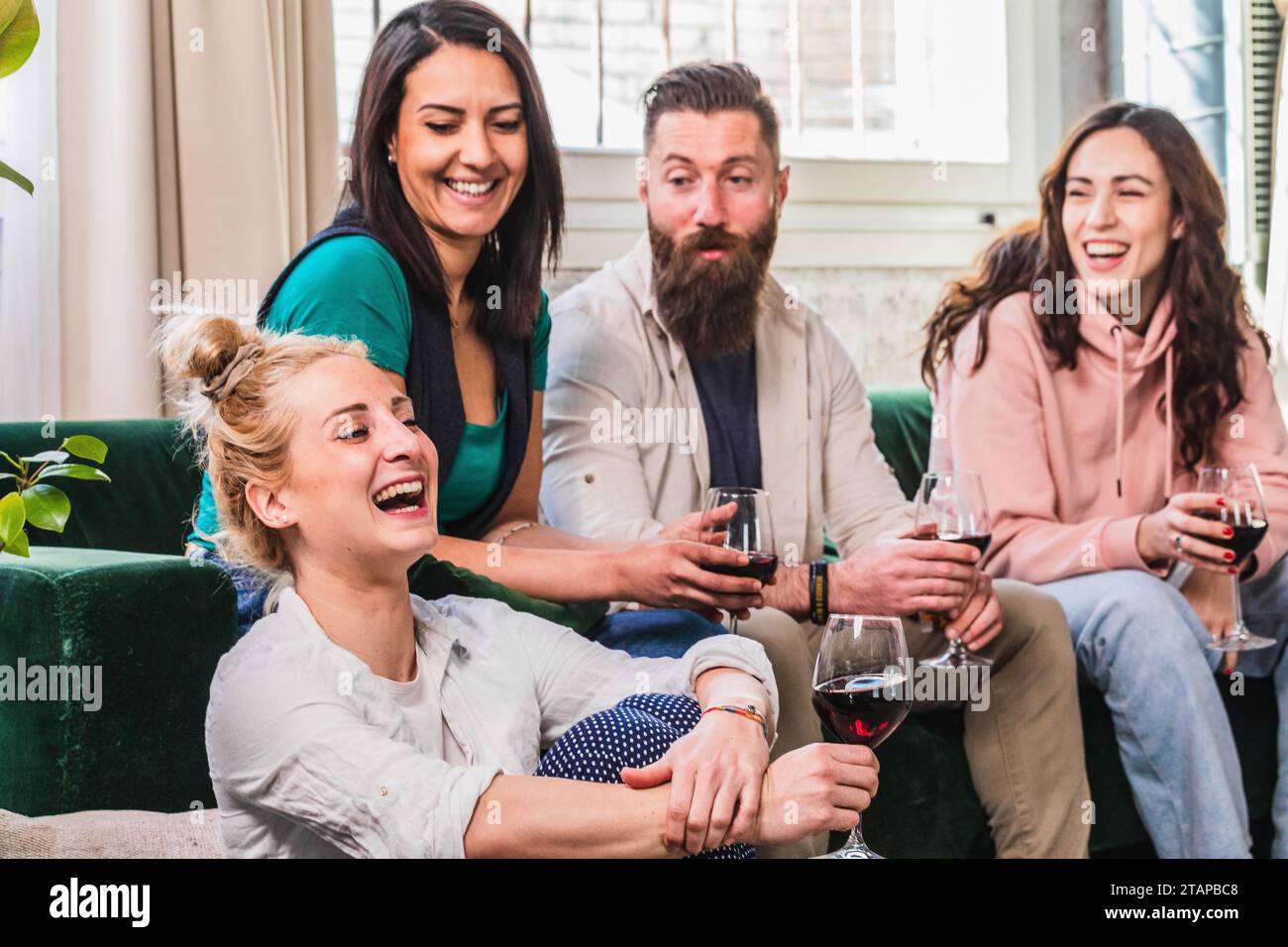 Playful scene of friends at home laughing and joking with each other. Fun evening among young boys. Multiethnic group indoors Stock Photo