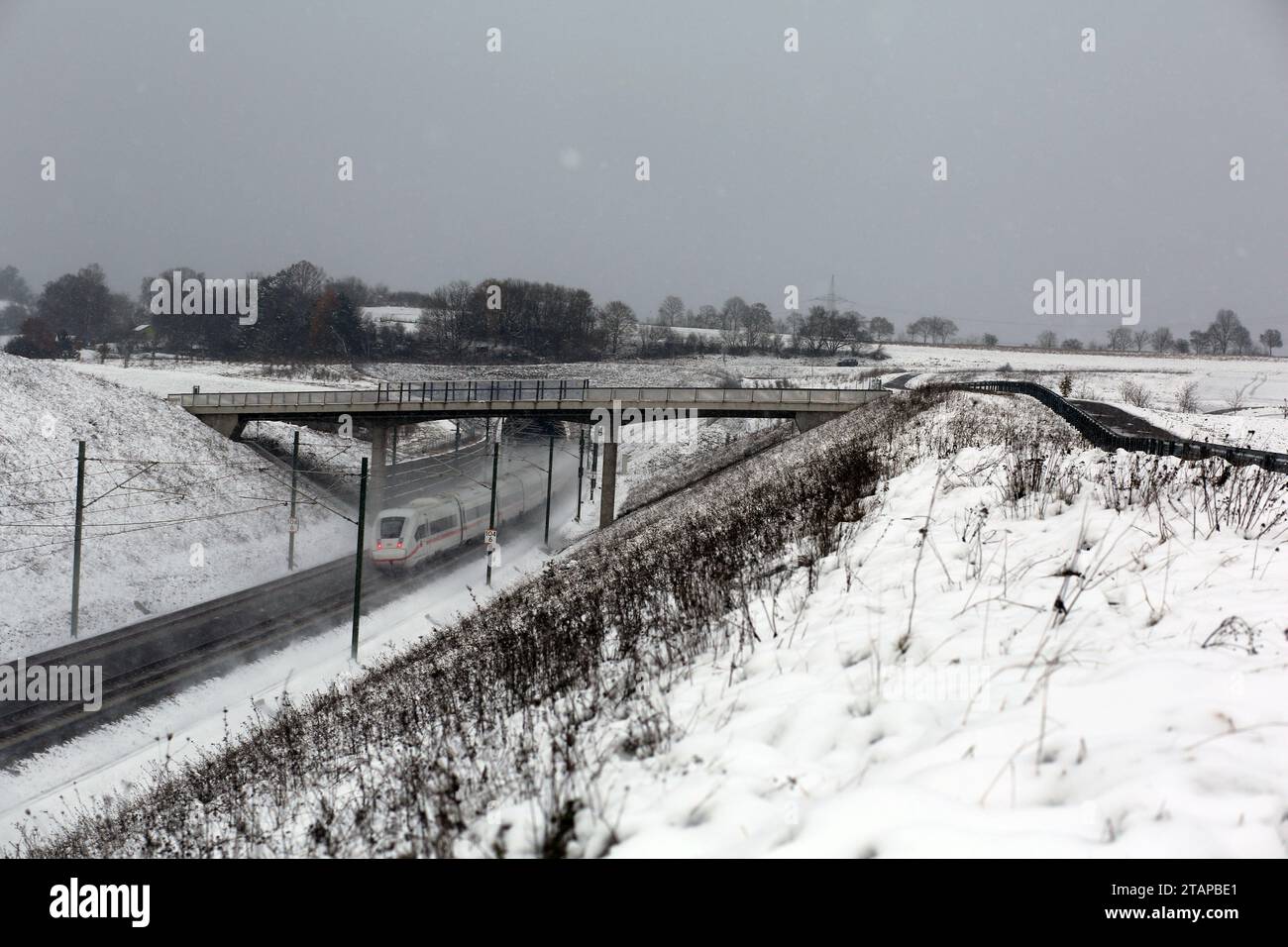Coburg, Germany. 2nd December 2023. Cold weather in northern Bavaria after heavy snowfalls as a train passes slowly under a footbridge. Credit: Clearpiximages/Alamy Live News Stock Photo