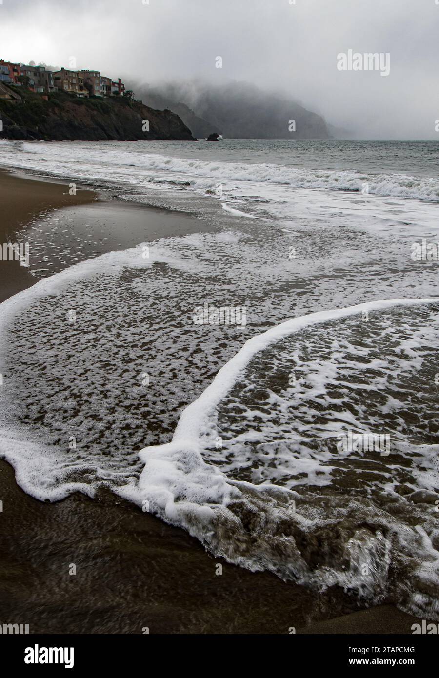Waves and fog rolls in onto Baker Beach, San Francisco, California Stock Photo