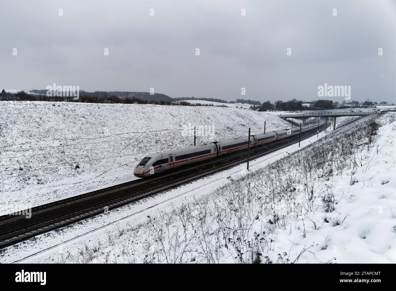 Coburg, Germany. Dec 2 2023. Cold weather in northern Bavaria after heavy snowfalls as a train passes under a footbridge. Credit: Clearpiximages/Alamy Live News Stock Photo