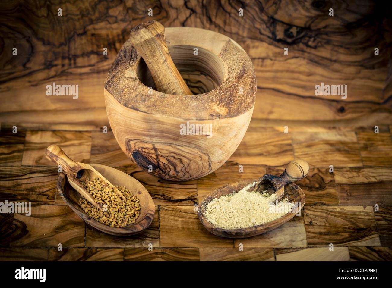 Fenugreek seeds whole or ground on olive wood Stock Photo