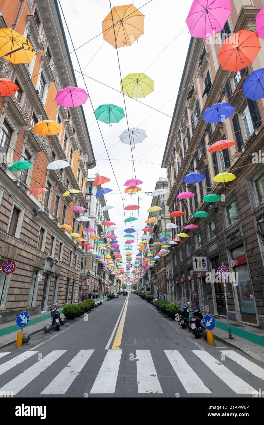 Multicoloured open umbrellas on the sky in a narrow street. Traditional Italian architecture on Bianchi street, Genova Italy. Stock Photo