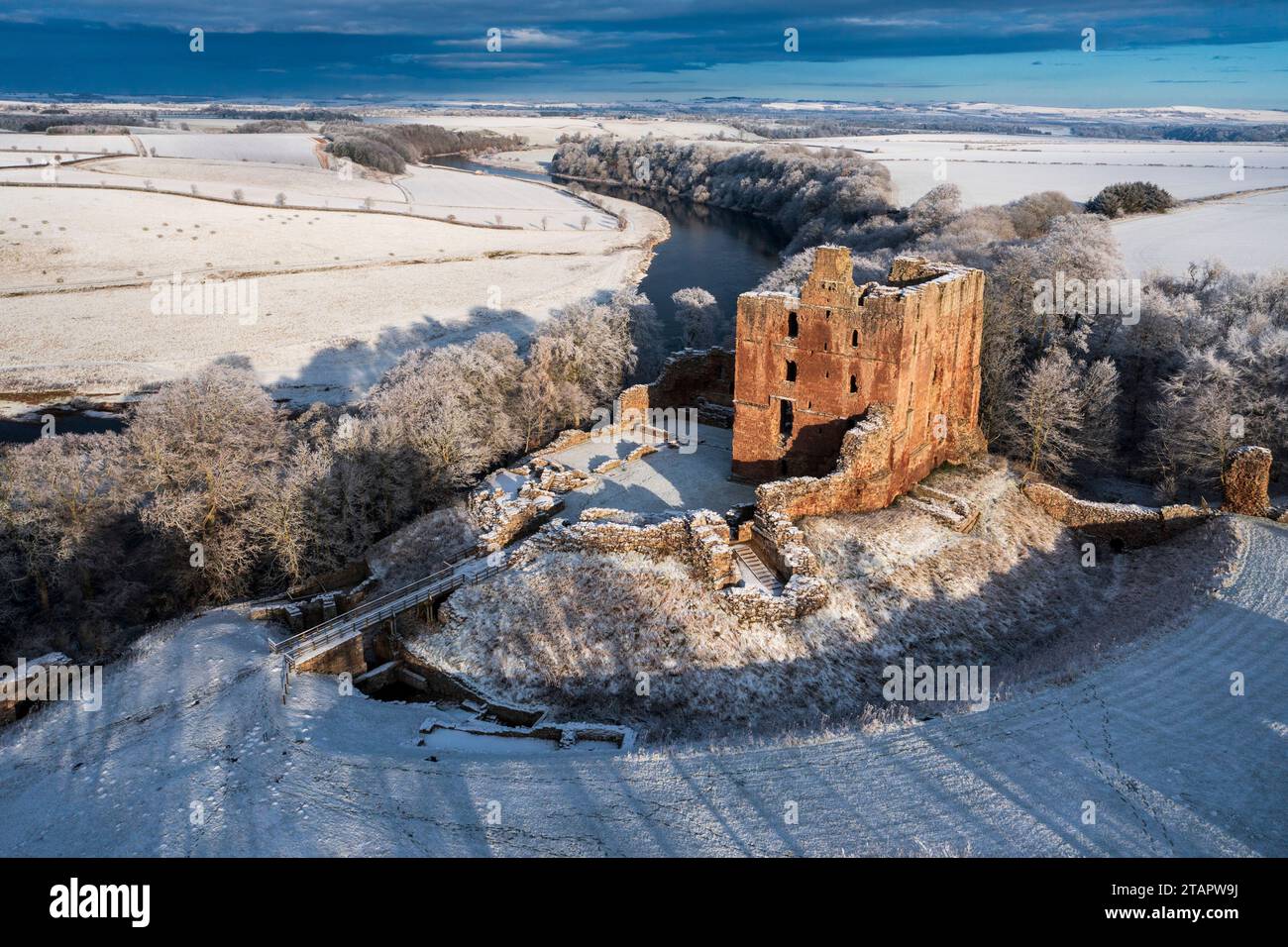 A snow covered landscape with Norham Castle in winter sunshine, Stock Photo