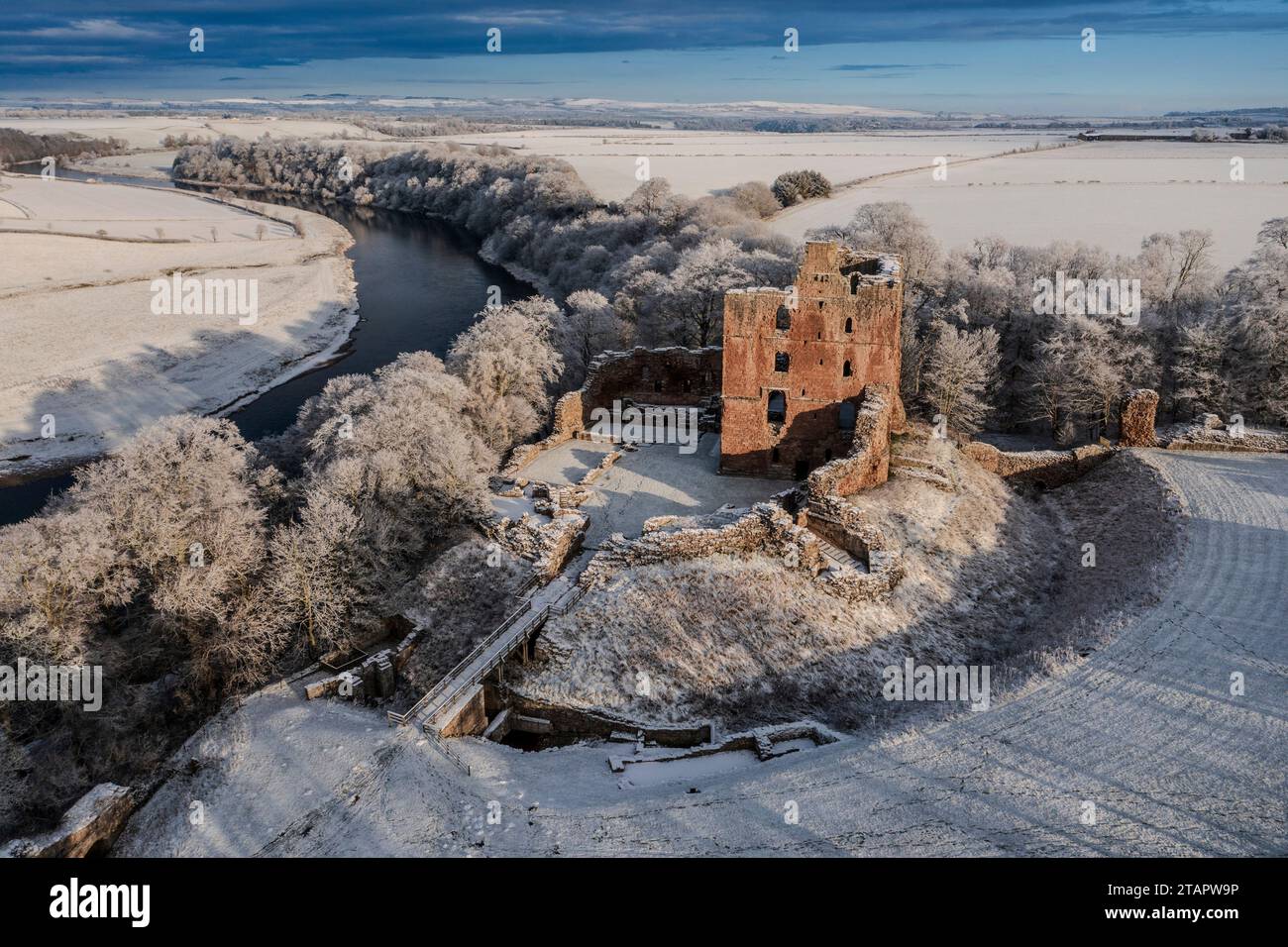 A snow covered landscape with Norham Castle in winter sunshine, Stock Photo