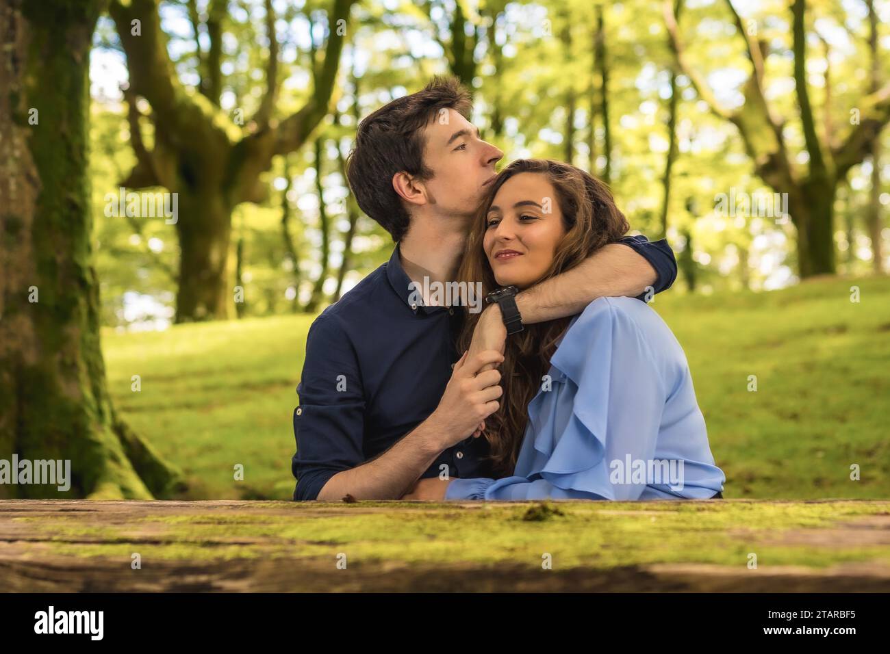 Frontal horizontal photo of tender scene of lovers embracing in a forest Stock Photo