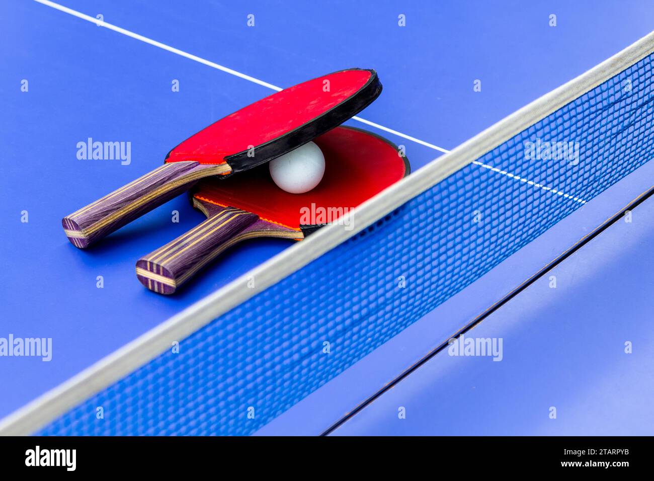 travel to ping pong rackets and ball on blue table for