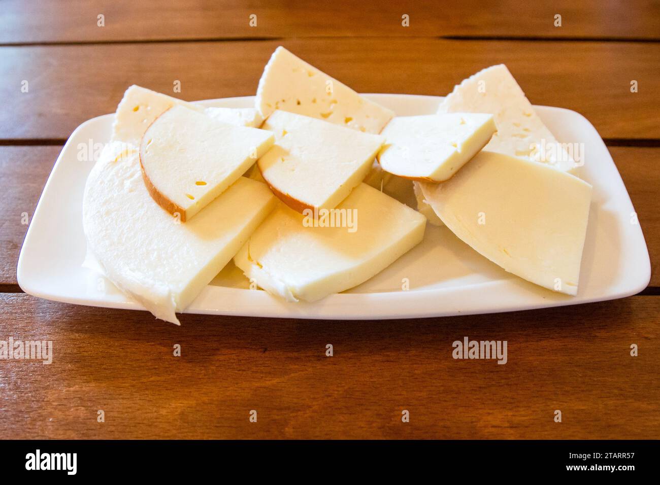 travel to Georgia - portion of various sliced Georgian brine cheeses on plate on wooden table in local cafe in Batumi city Stock Photo