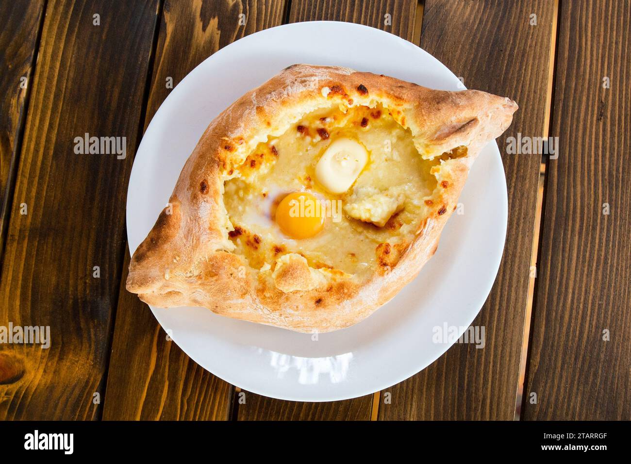 travel to Georgia - top view of khachapuri in Adjarian style (boat shaped with soft cheese, egg, butter) in local cafe in Batumi city Stock Photo