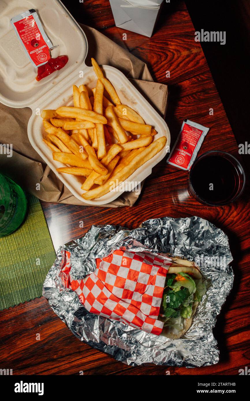 takeout meal with chicken shawarma, French fries, ketchup packets, and