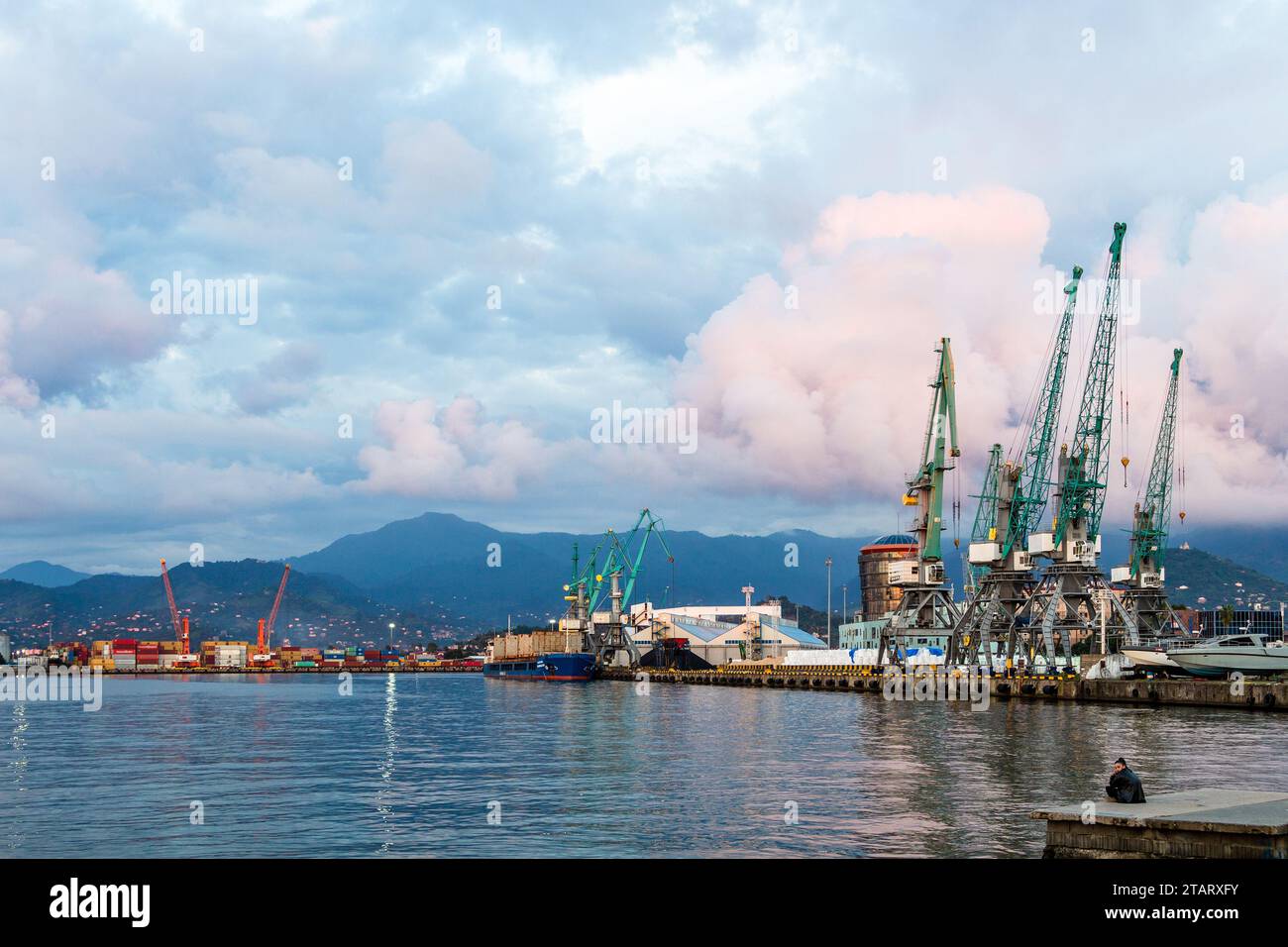 Batumi, Georgia - September 16, 2023: view of waterfront of old harbor of Batumi city in autumn evening with pink clouds over blue mountain on backgro Stock Photo