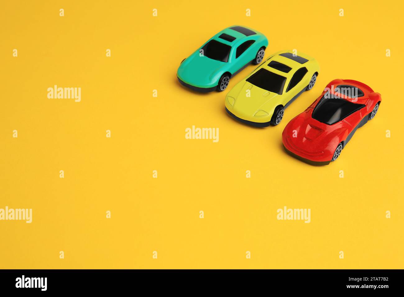 Different bright cars on yellow background, space for text. Children`s ...