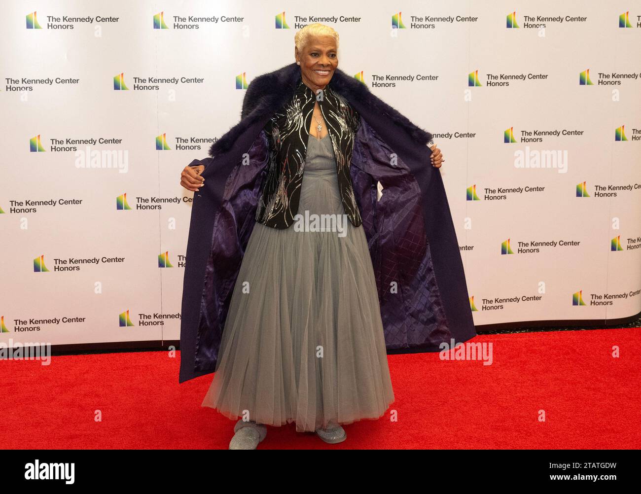 Dionne Warwick opens her coat to show-off her dress as she arrives for ...