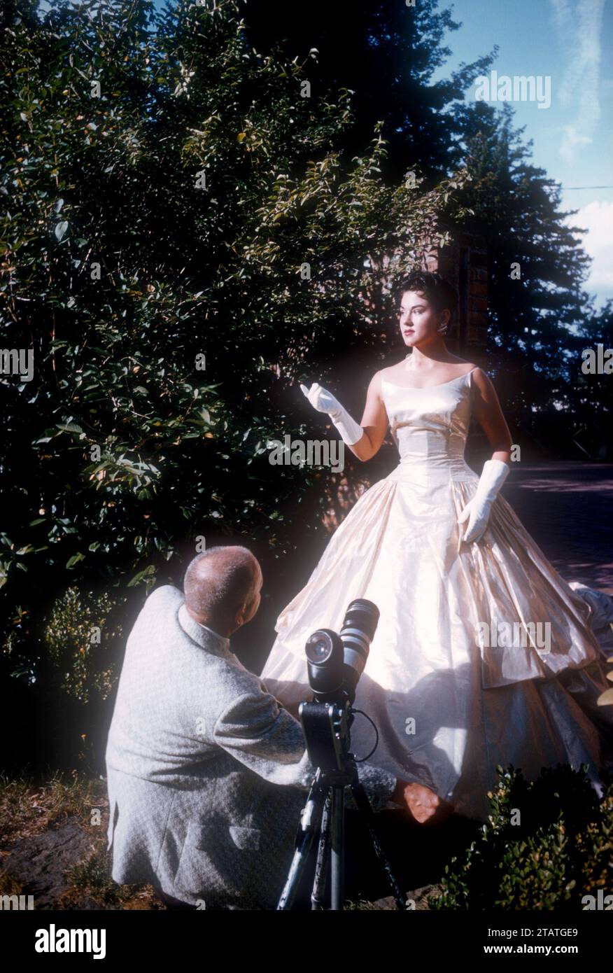 1951 A Woman Has Her Dress Fixed By The Cameraman Before Taking Photos 