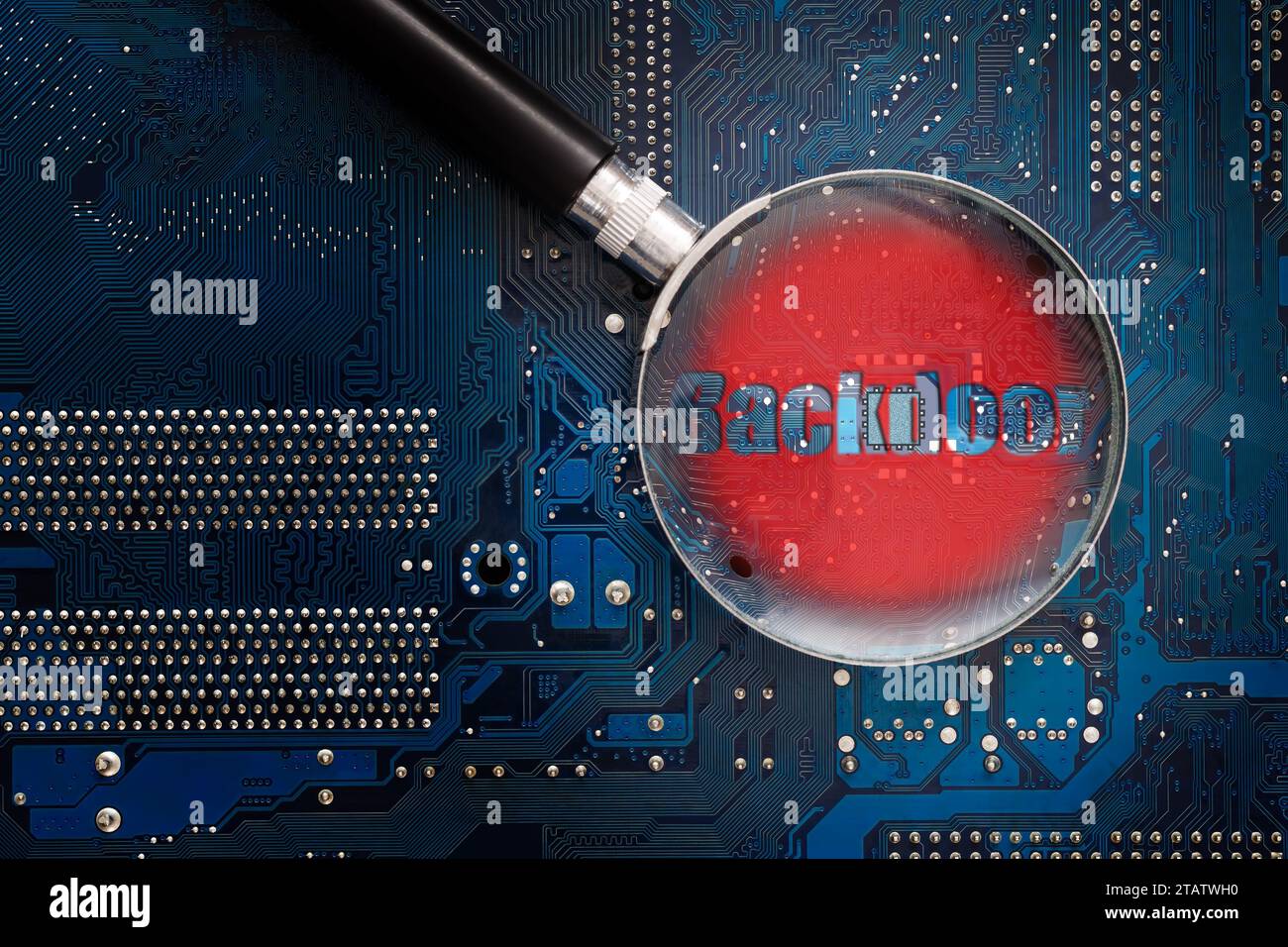 Hardware backdoor chip on a printed circuit board. A look through a magnifying glass with a red warning. Concept of computer security and searching fo Stock Photo