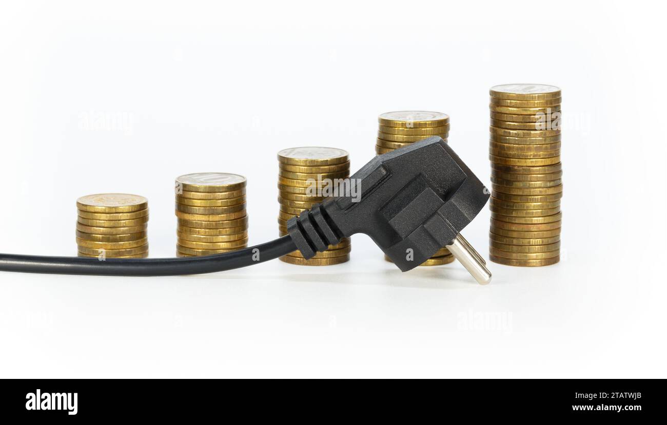An electric plug against a background of stacks of coins, in the form of a growing diagram on a light background. The concept of increasing electricit Stock Photo
