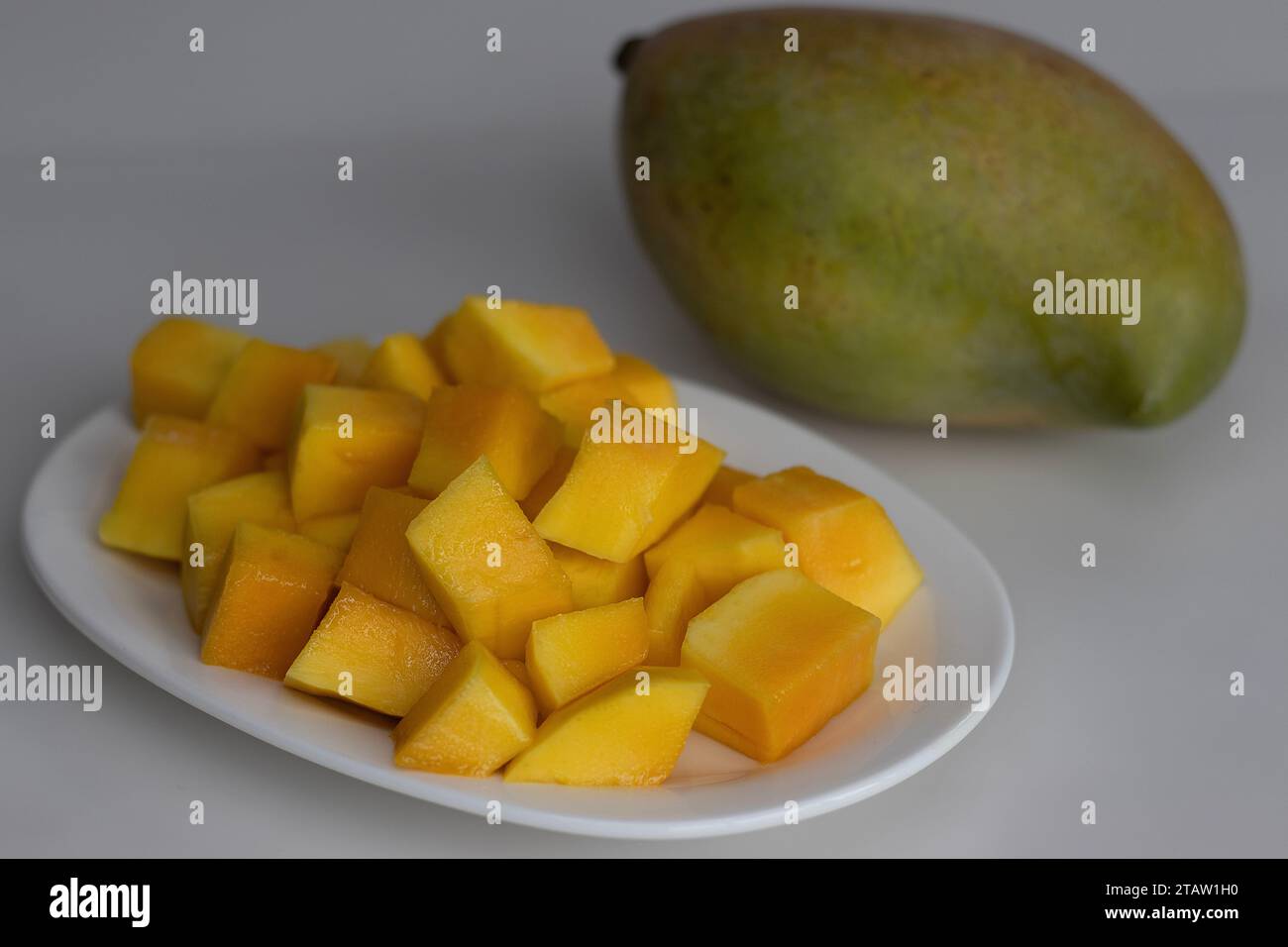 Fresh large totapuri mangoes sliced to small pieces, juicy and vibrant in color. It is oblong in shape and has a prominent beak like pointed end. Shot Stock Photo