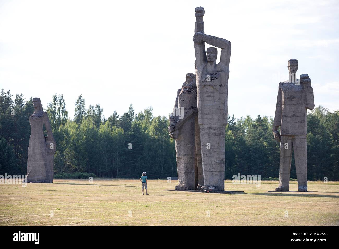 Tourist looking at the giant sculptures at Salaspils Memorial, one of