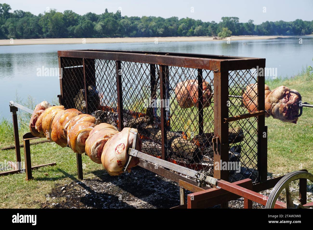 closeup of yummy pork roasts on spits cooking at an outdoor bbq on display for sale by the loire river in france Stock Photo