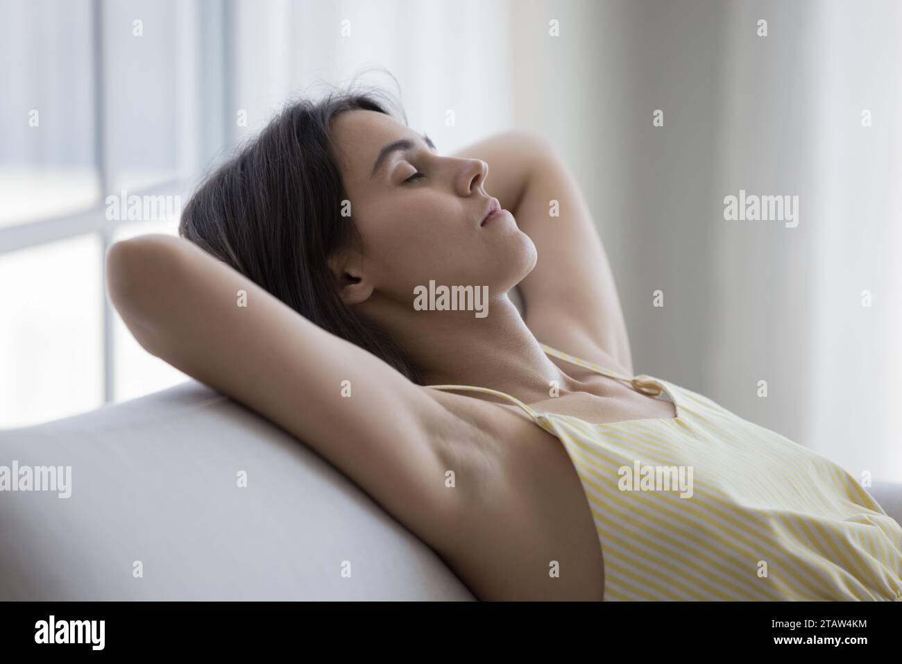 Silent attractive woman having daytime nap leaned on couch Stock Photo