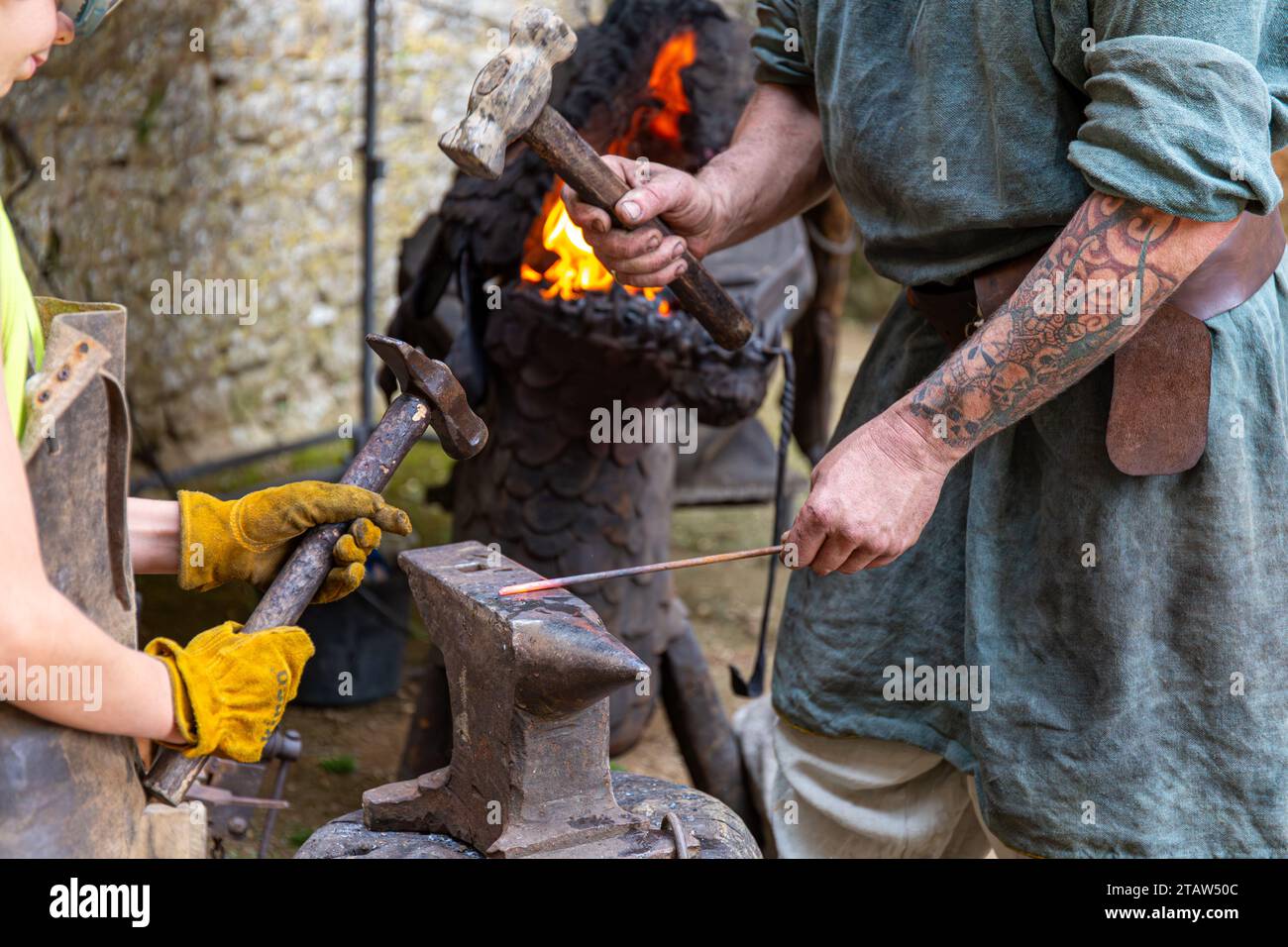 Demonstration of blacksmithing in a dragon head shaped forge during medieval festival in Bonaguil castle, France Stock Photo