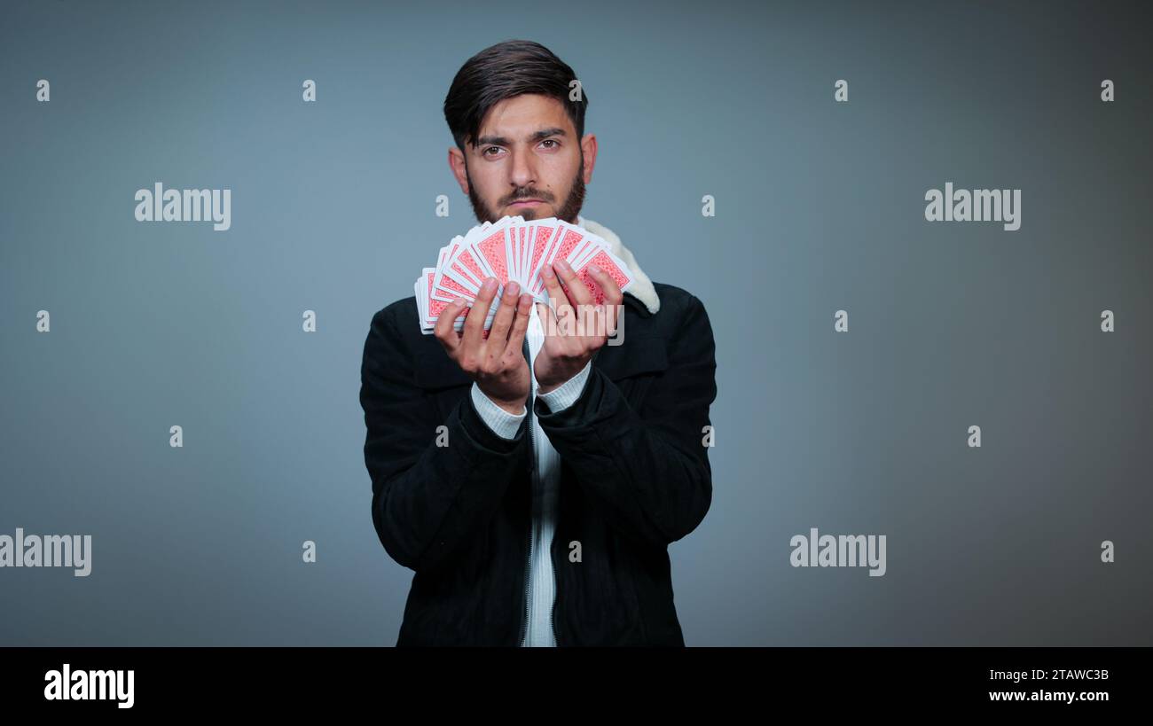 Young Man Holding Cards against gray background, Focus on Cards, Playing cards Stock Photo