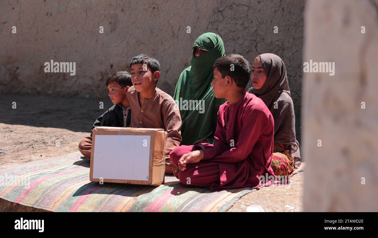 Needy Afghan family receiving donations | Children expressing happiness after receiving aid food packs. Stock Photo