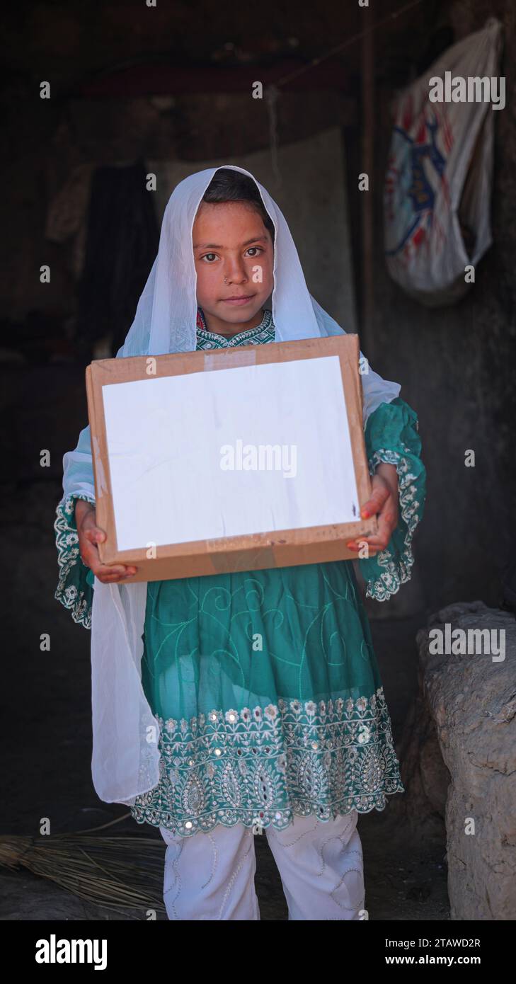 Needy Afghan girl receiving donations | Children expressing happiness after receiving aid food packs | Needy kid holding aid pack Stock Photo