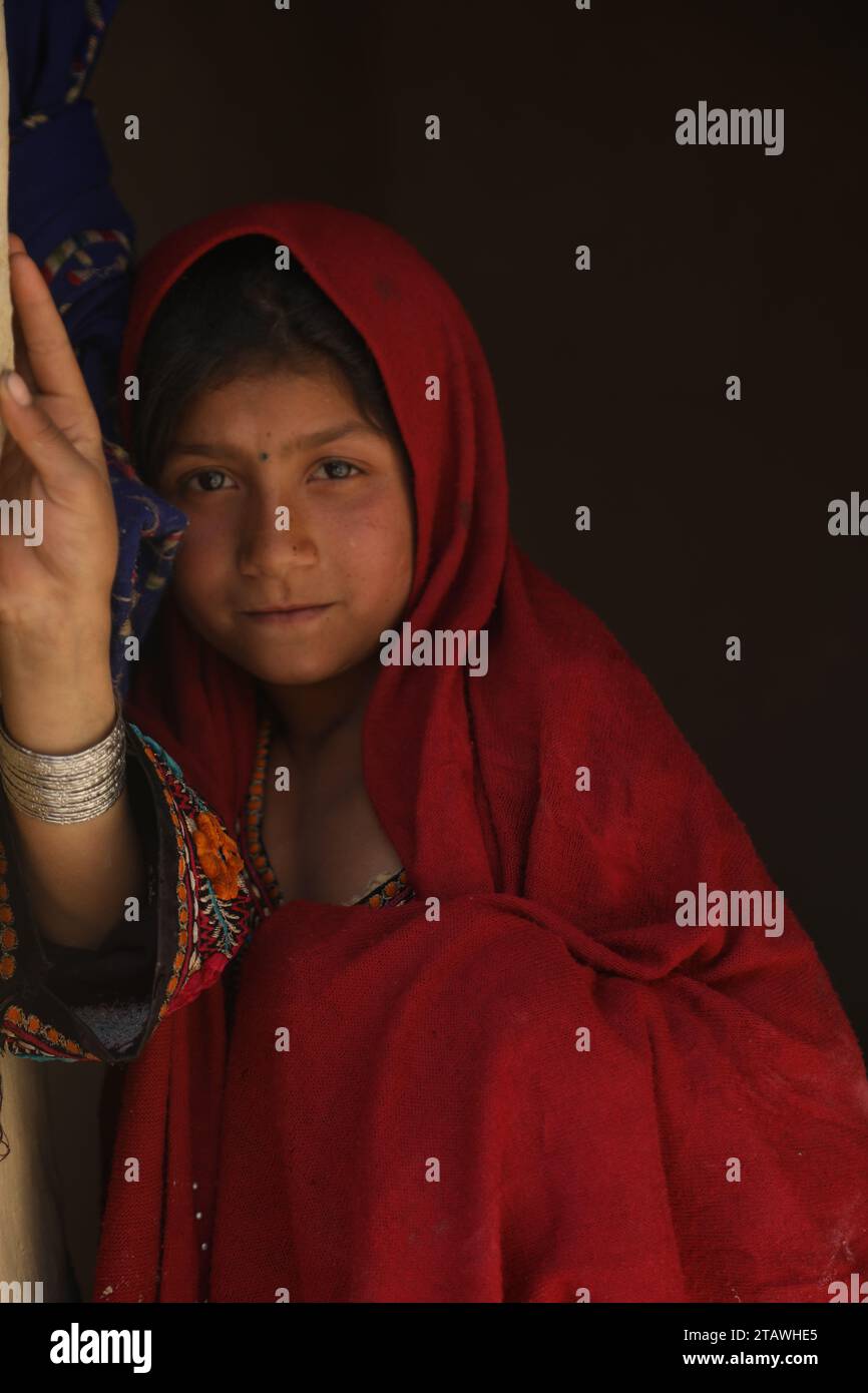 Happy Afghan young girl with a traditional outfit, smiling, looking at the camera. Stock Photo