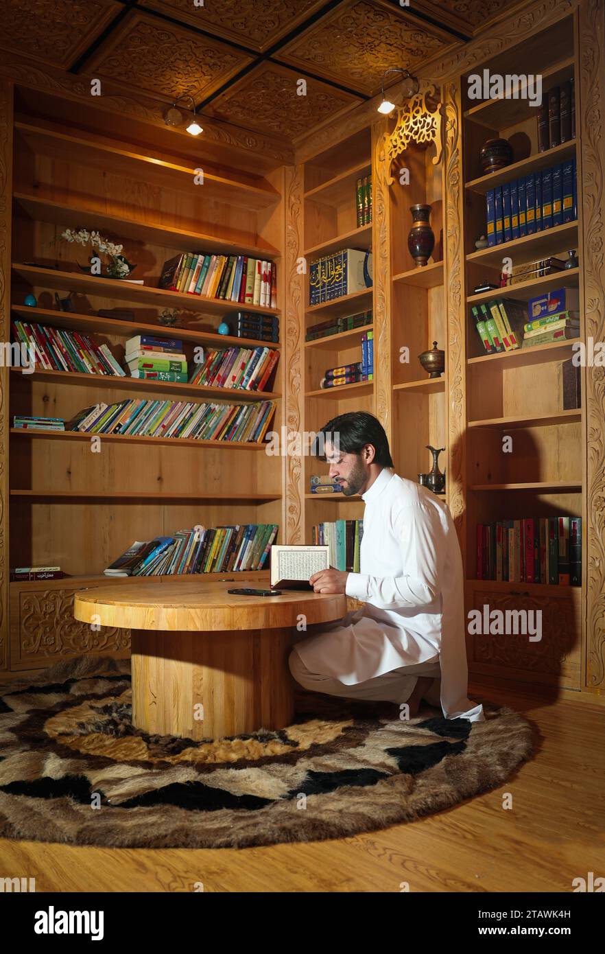 Muslim man reading holy Quran. Holy Quran in Hand with Arabic text meaning of Al Quran. Stock Photo