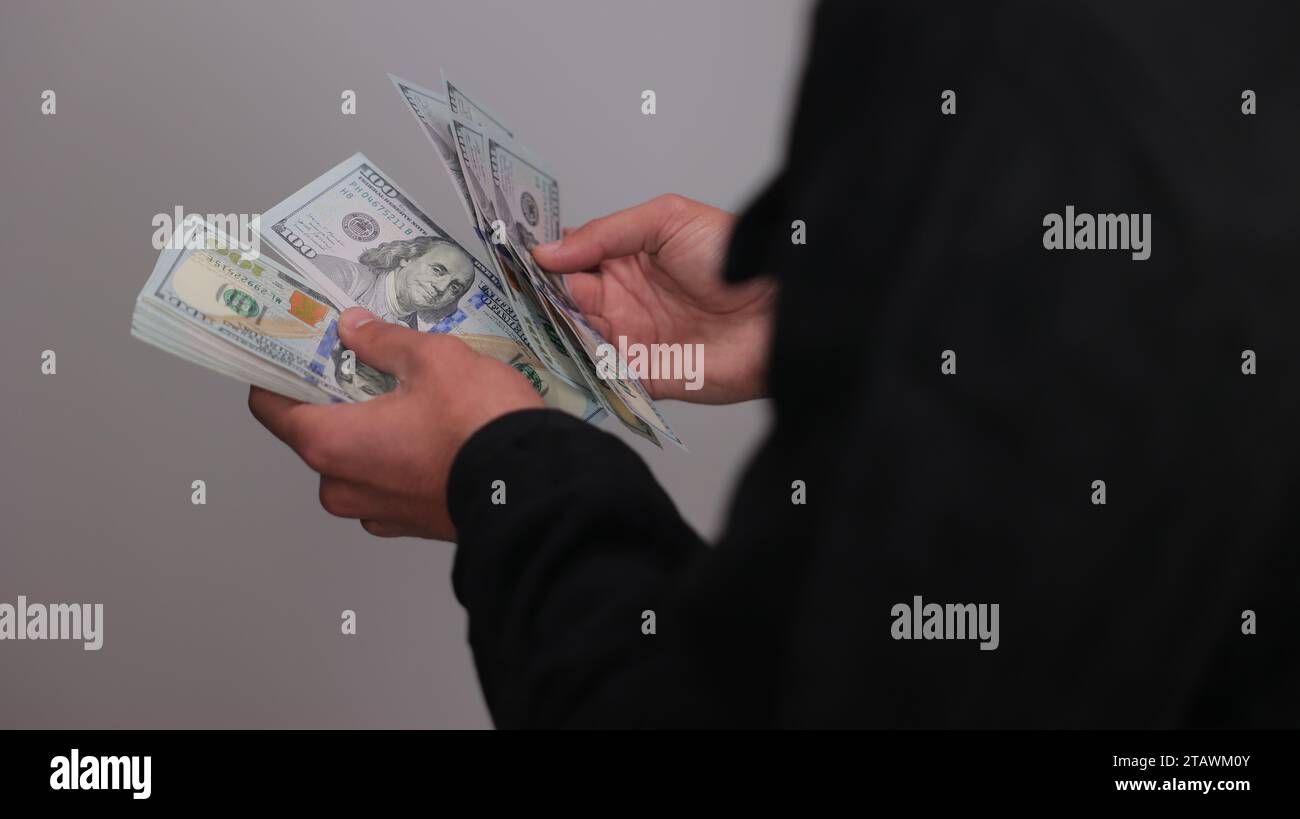 American dollars or US dollars: hands counting one hundred American money or 100 USD. Stock Photo